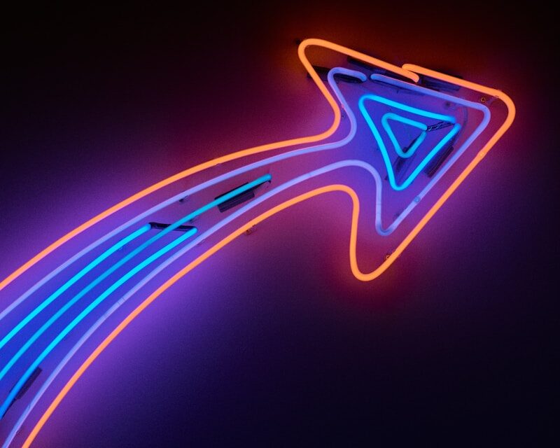 Red and blue neon arrow pointing up and to the right